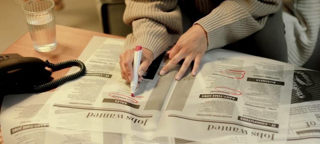 Lady looking through a newspaper for job advertisements